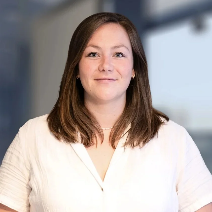 Portrait von Laura Rücker vor der hellen Fensterfront im Büro