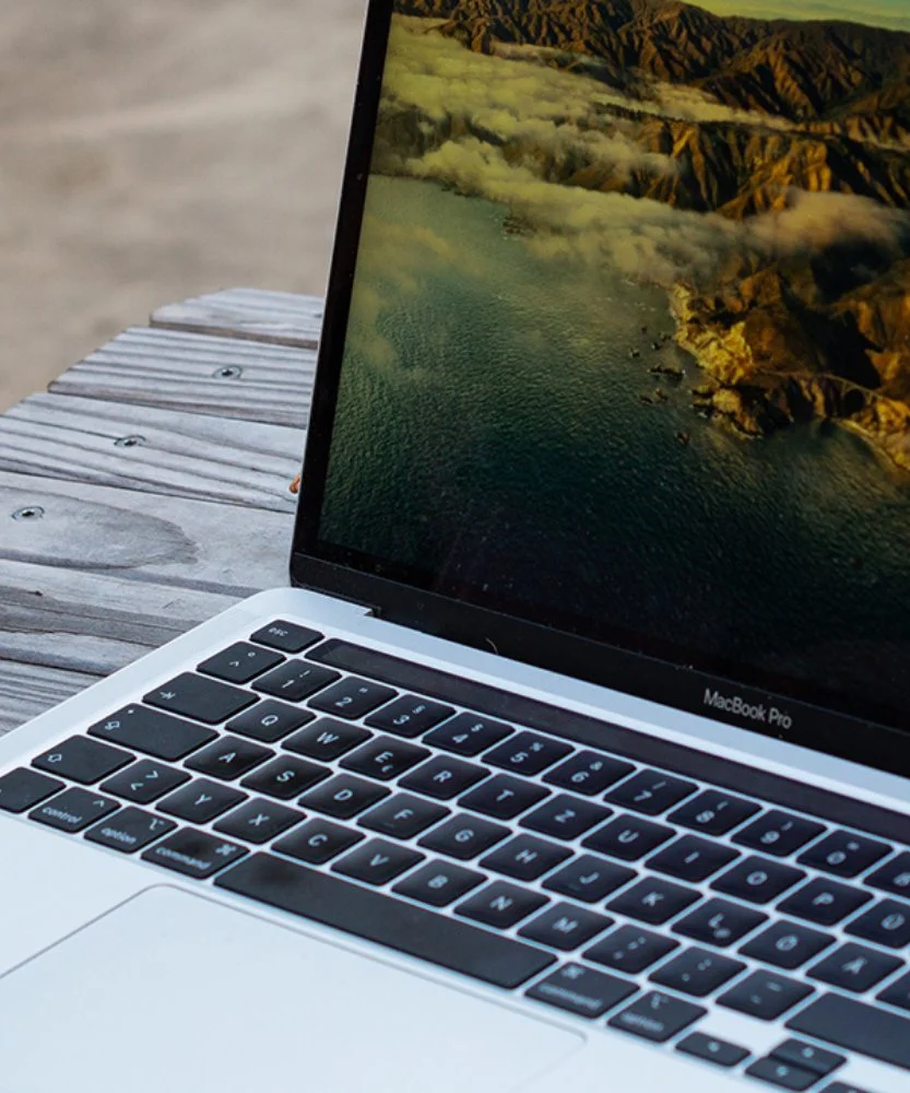 Aufgeklapptes MacBook auf einer Holzbank im Innenhof in Hannover