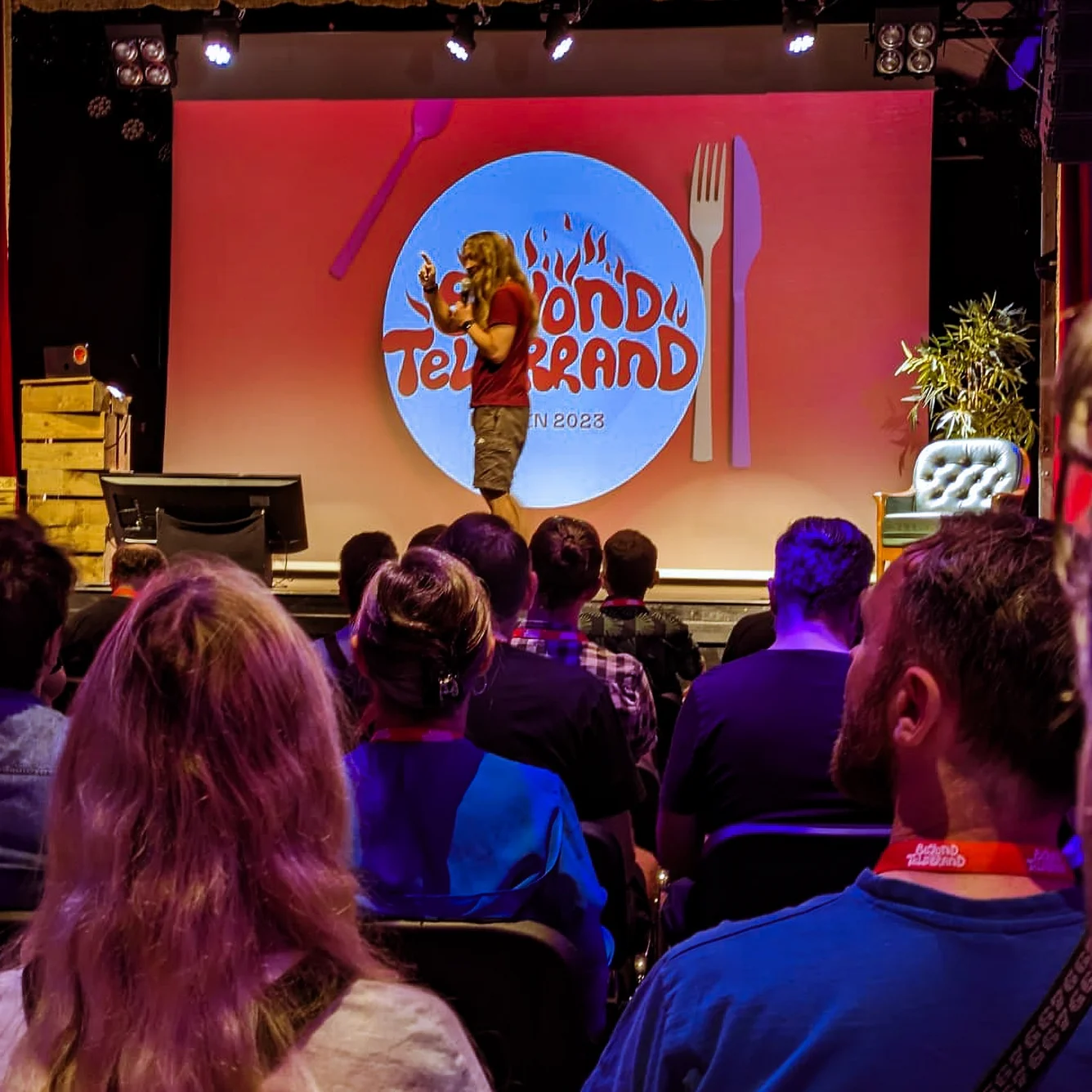 Publikum im dunklen Saal blickt auf die Bühne der Konferenz beyond tellerrand