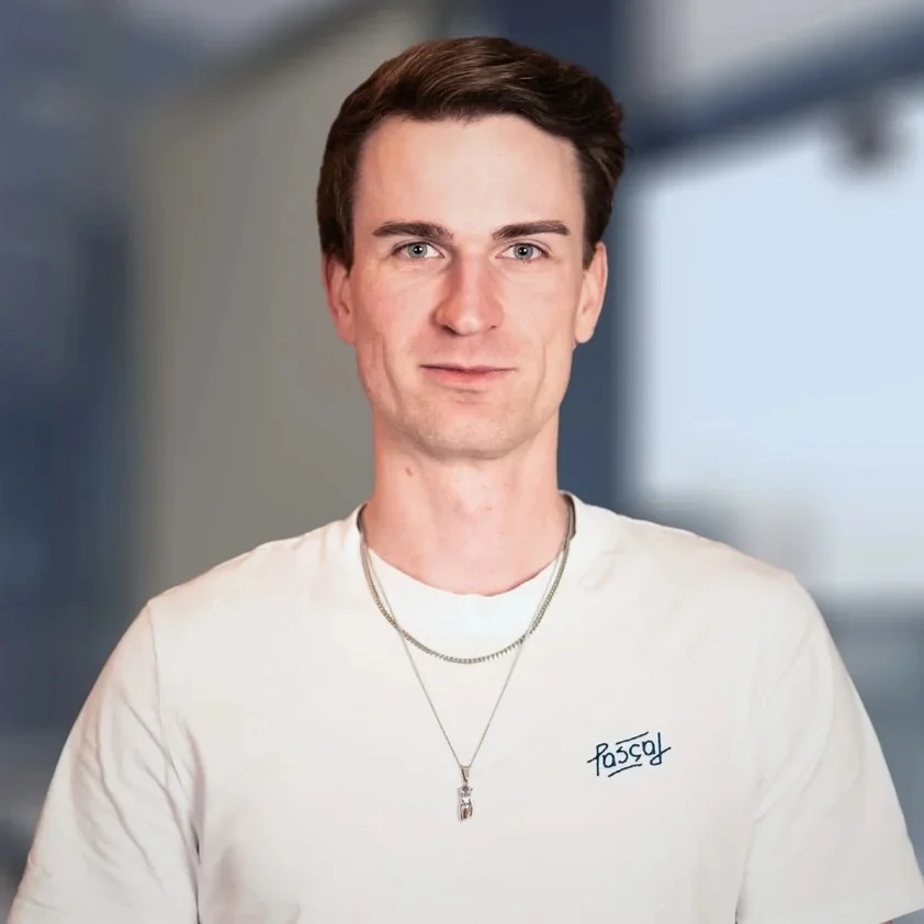Portrait von Pascal Schaar vor der hellen Fensterfront im Büro